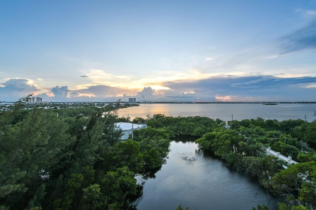 aerial view at dusk featuring a water view