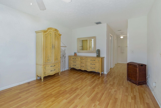 unfurnished bedroom featuring ceiling fan, a textured ceiling, and light hardwood / wood-style flooring