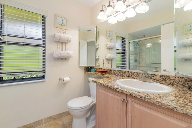 bathroom featuring toilet, vanity, tile patterned floors, and a shower with door