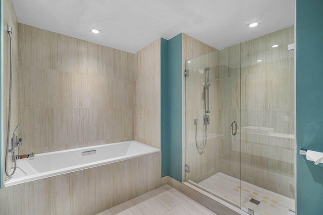 bathroom featuring shower with separate bathtub and tile patterned flooring