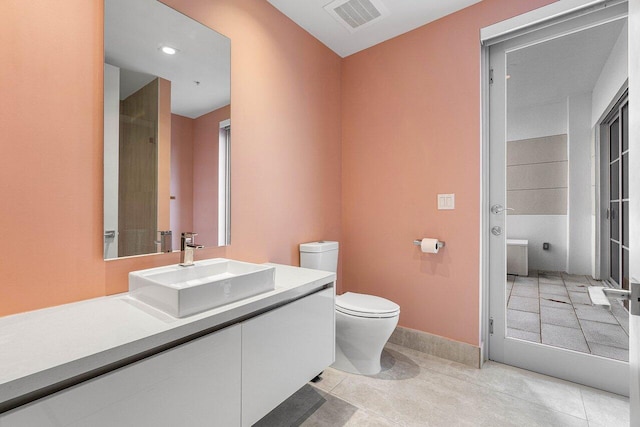 bathroom featuring tile patterned floors, vanity, and toilet