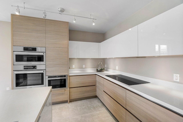 kitchen featuring black electric stovetop, white cabinets, stainless steel double oven, light brown cabinets, and light tile patterned floors