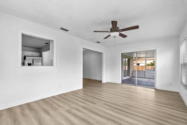 unfurnished room featuring ceiling fan, a textured ceiling, and light hardwood / wood-style flooring