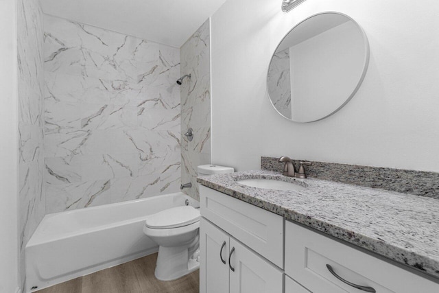 full bathroom featuring hardwood / wood-style floors, vanity, toilet, and tiled shower / bath