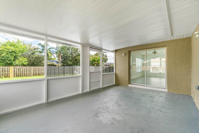 unfurnished sunroom featuring vaulted ceiling with beams and ceiling fan