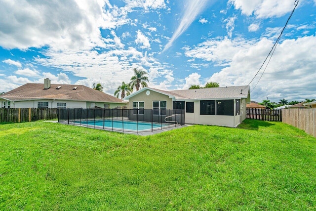 rear view of property with a fenced in pool and a yard