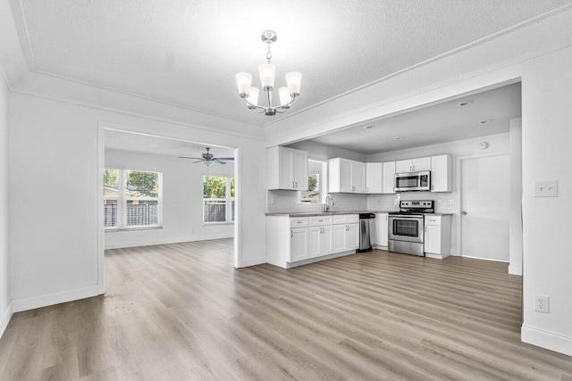 kitchen featuring stainless steel appliances, light wood-type flooring, sink, and white cabinetry