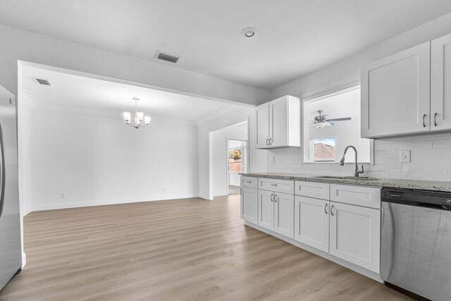 kitchen featuring tasteful backsplash, sink, white cabinets, light hardwood / wood-style flooring, and appliances with stainless steel finishes