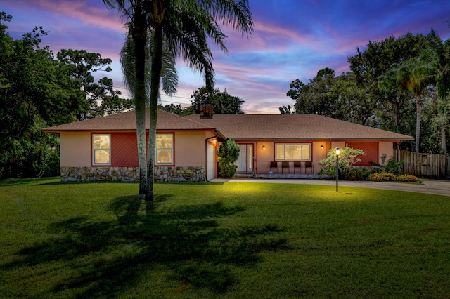 single story home featuring a lawn