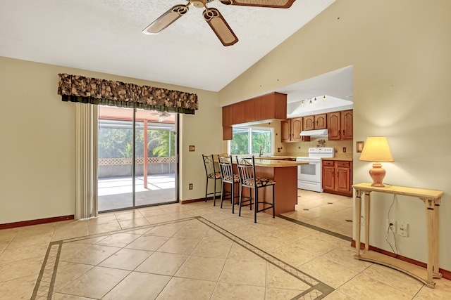 kitchen featuring a breakfast bar area, kitchen peninsula, light tile patterned floors, white electric stove, and ceiling fan