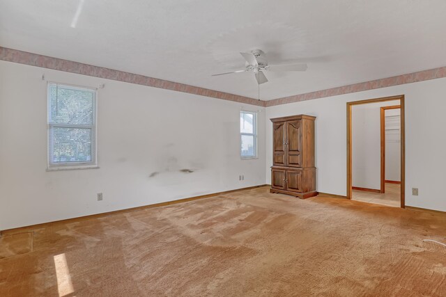 unfurnished bedroom with ceiling fan, light carpet, and multiple windows