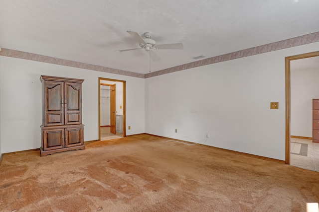 spare room with ceiling fan and light colored carpet