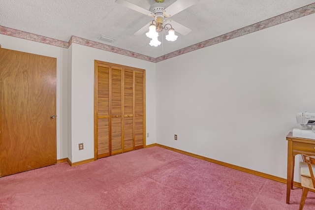 unfurnished bedroom with a closet, ceiling fan, carpet flooring, and a textured ceiling