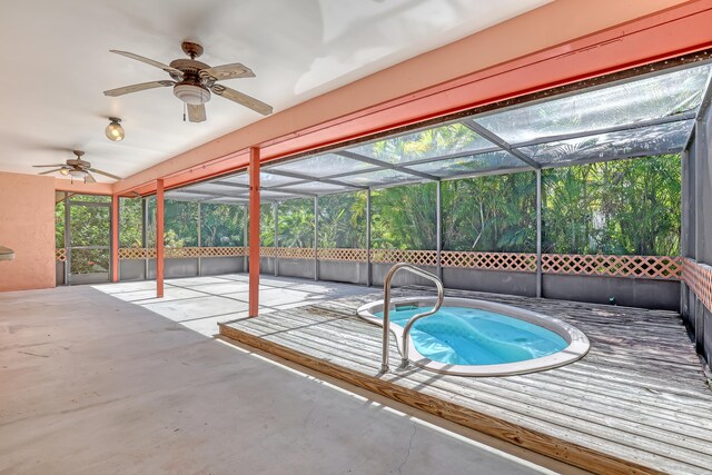 view of swimming pool featuring glass enclosure, ceiling fan, and a patio area