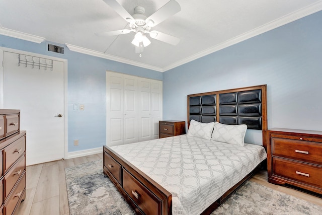 bedroom featuring ceiling fan, light hardwood / wood-style flooring, crown molding, and a closet