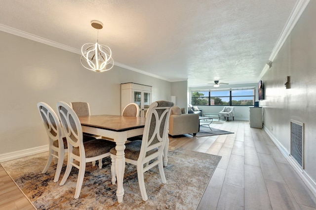 dining area with a textured ceiling, crown molding, ceiling fan with notable chandelier, and light hardwood / wood-style flooring