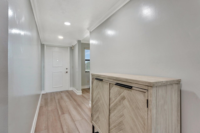 hallway with light hardwood / wood-style flooring and ornamental molding