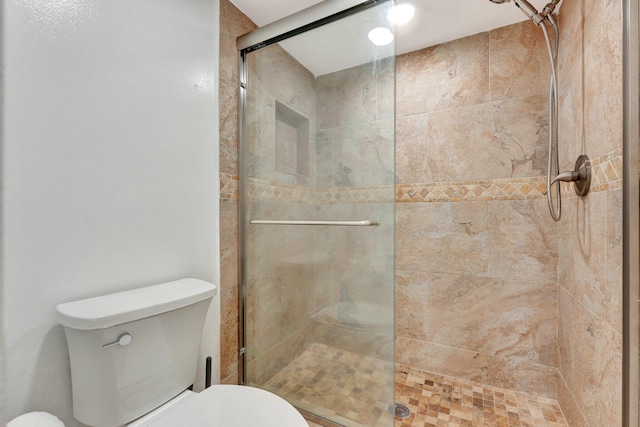 bathroom featuring walk in shower and toilet