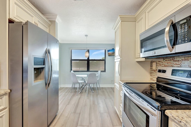 kitchen with appliances with stainless steel finishes, hanging light fixtures, crown molding, and light stone counters