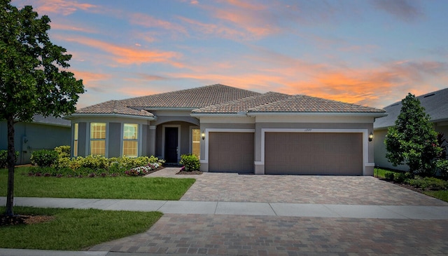 mediterranean / spanish-style home with a yard and a garage