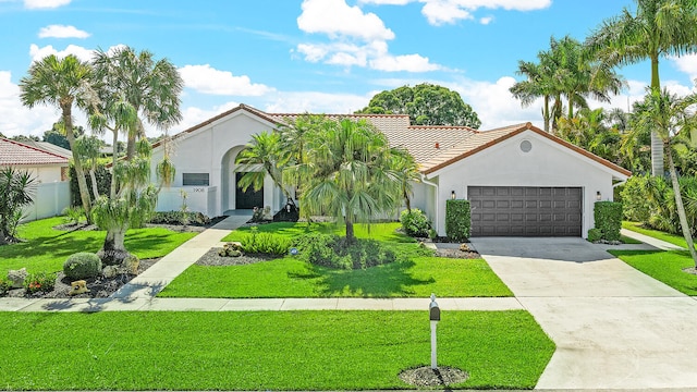 mediterranean / spanish-style home with a garage and a front lawn