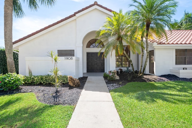 mediterranean / spanish-style house with a front yard