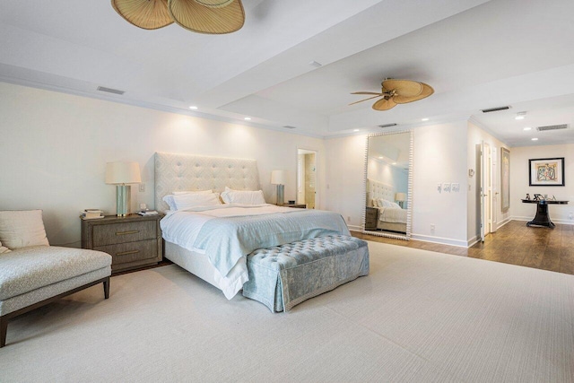 bedroom with ornamental molding, a tray ceiling, ceiling fan, and hardwood / wood-style flooring