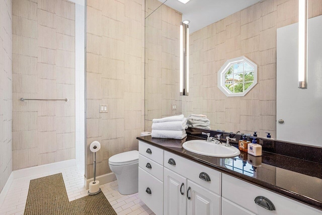 bathroom featuring vanity, toilet, walk in shower, tile walls, and tile patterned flooring