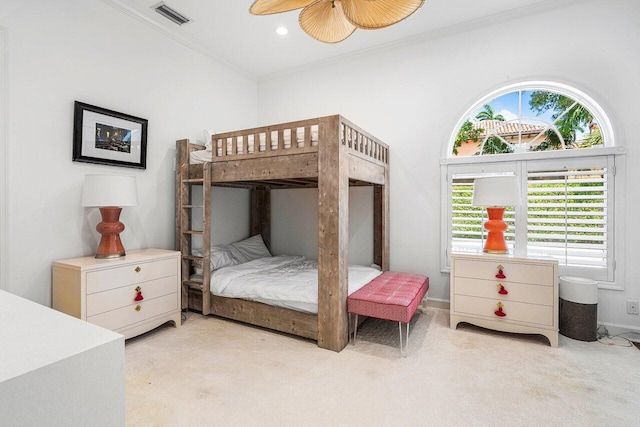 bedroom with ceiling fan, light carpet, and crown molding