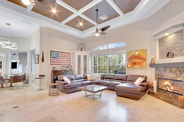 living room featuring ceiling fan with notable chandelier, a towering ceiling, and coffered ceiling