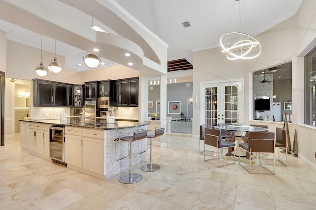 kitchen featuring decorative backsplash, a center island, beverage cooler, french doors, and dark stone counters