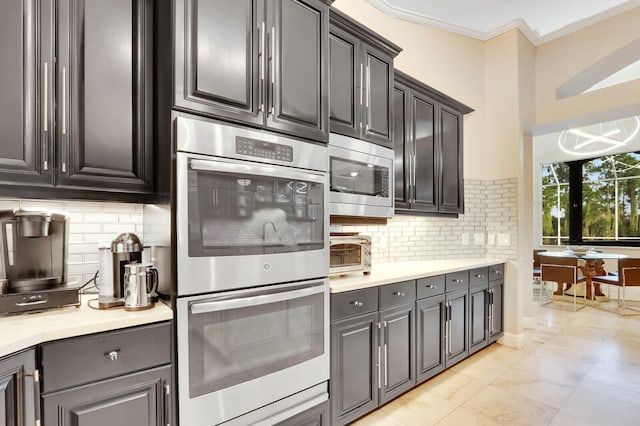 kitchen with ornamental molding, stainless steel appliances, and tasteful backsplash