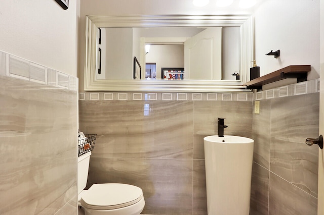 bathroom with tile walls and toilet