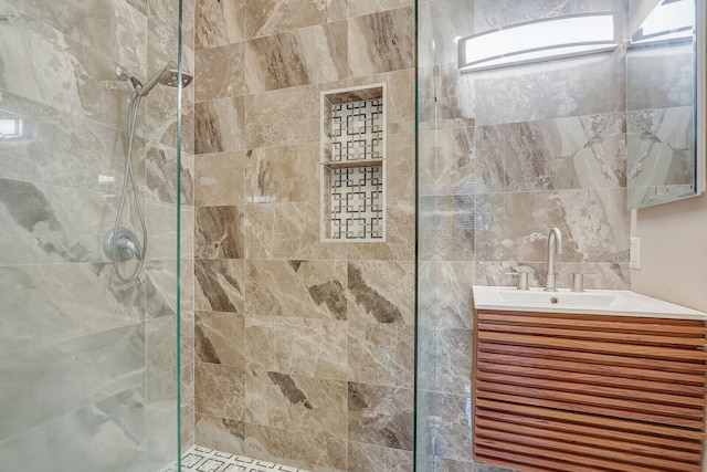 bathroom featuring a tile shower, tile walls, and vanity