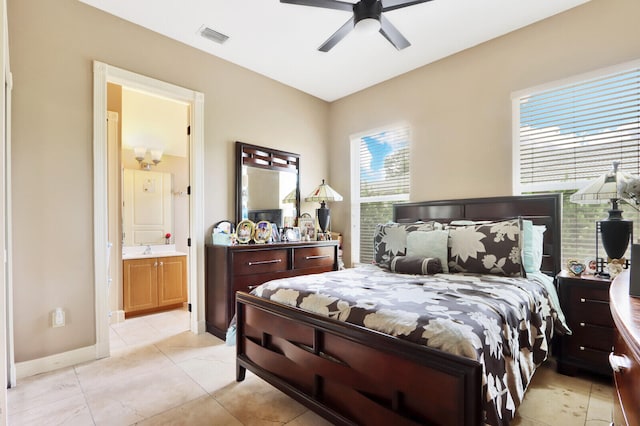 bedroom featuring ceiling fan, ensuite bath, light tile patterned floors, and multiple windows