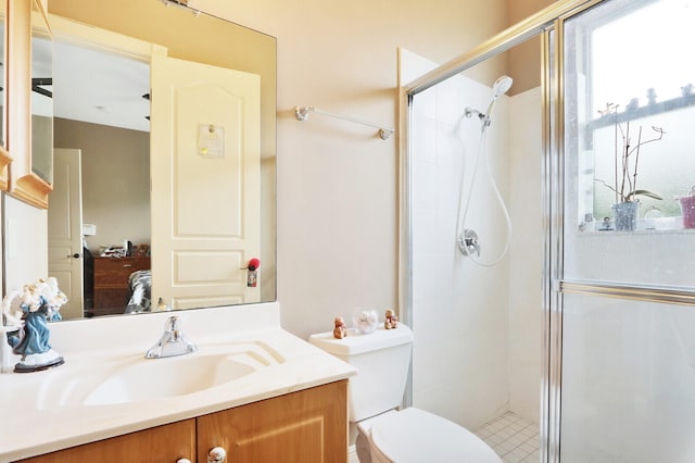 bathroom featuring a shower with door, vanity, and toilet