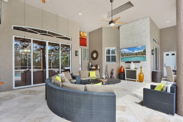 living room with ceiling fan and a high ceiling