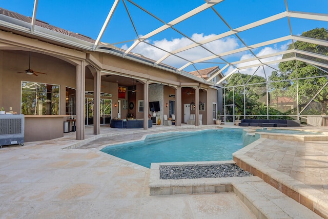 view of swimming pool featuring glass enclosure, an in ground hot tub, ceiling fan, and a patio