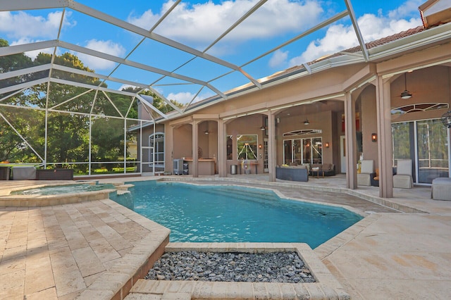 view of pool with ceiling fan, a patio, glass enclosure, and an in ground hot tub