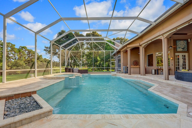 view of pool with a patio, an in ground hot tub, glass enclosure, and pool water feature