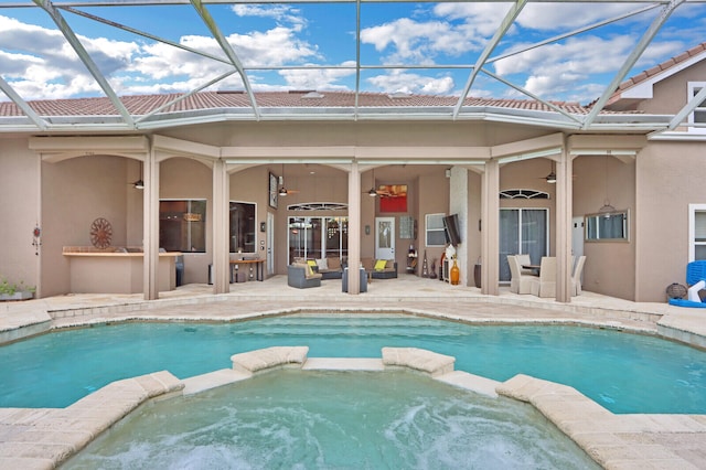 exterior space with ceiling fan, an in ground hot tub, a lanai, and a patio area