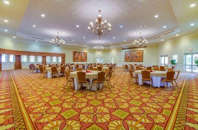 dining space with a tray ceiling, a towering ceiling, and ornamental molding