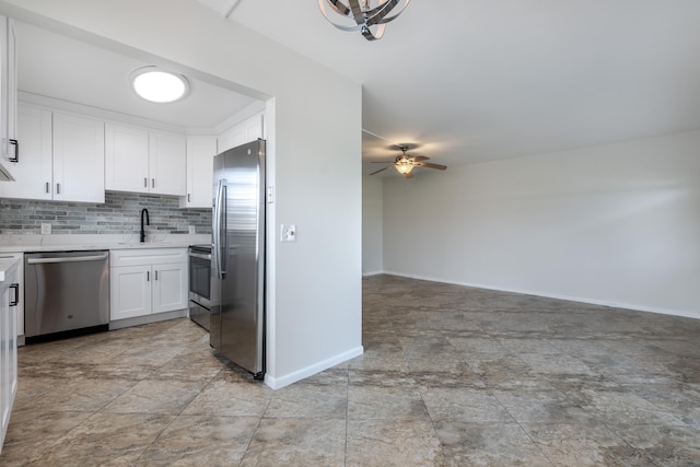 kitchen featuring appliances with stainless steel finishes, tasteful backsplash, white cabinets, ceiling fan, and sink