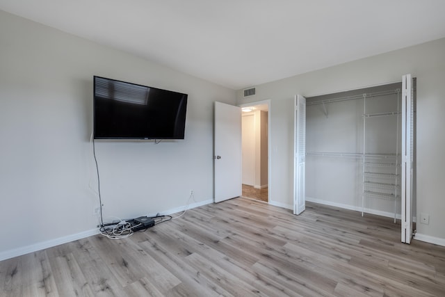 unfurnished bedroom with light hardwood / wood-style flooring and a closet