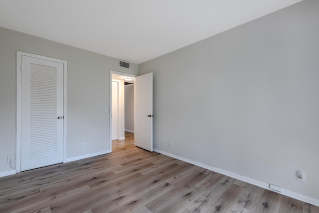 unfurnished bedroom featuring light wood-type flooring and a closet