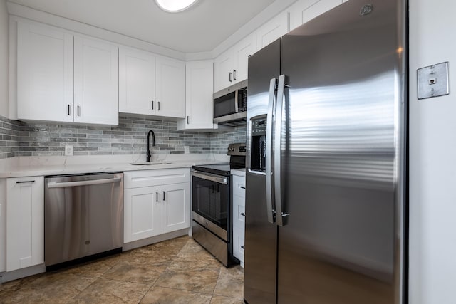 kitchen with white cabinetry, appliances with stainless steel finishes, tasteful backsplash, and sink