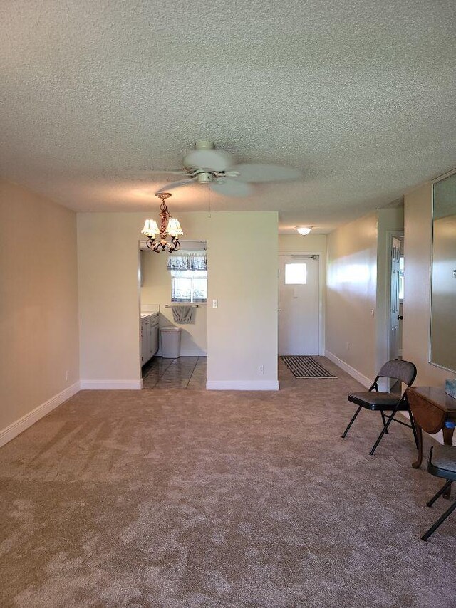 carpeted empty room featuring ceiling fan and a textured ceiling