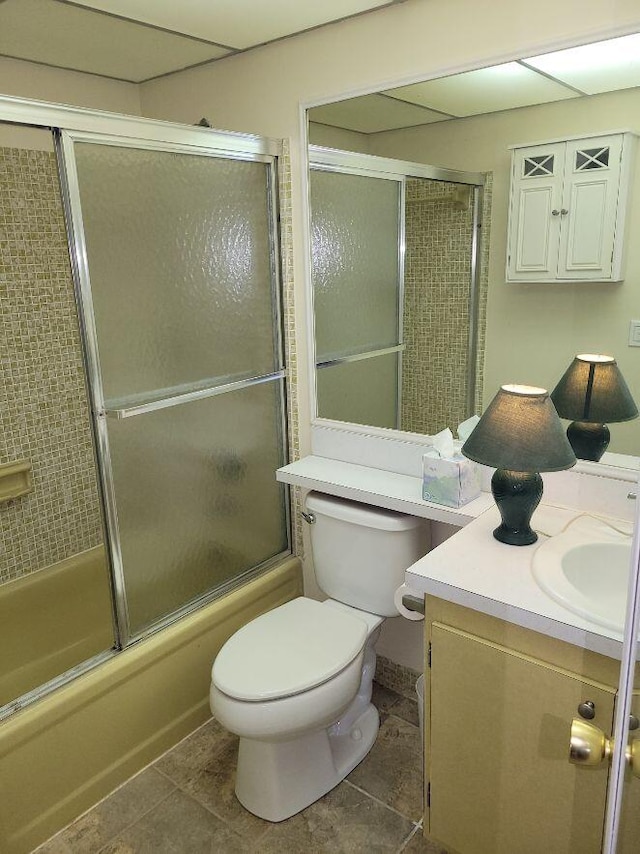 full bathroom featuring toilet, combined bath / shower with glass door, vanity, and tile patterned flooring