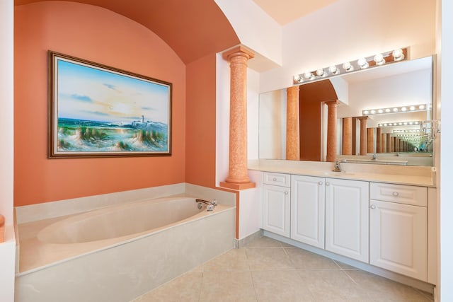 bathroom featuring tile patterned floors, decorative columns, vaulted ceiling, a bath, and vanity