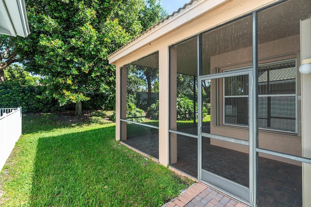 view of yard featuring fence and a sunroom